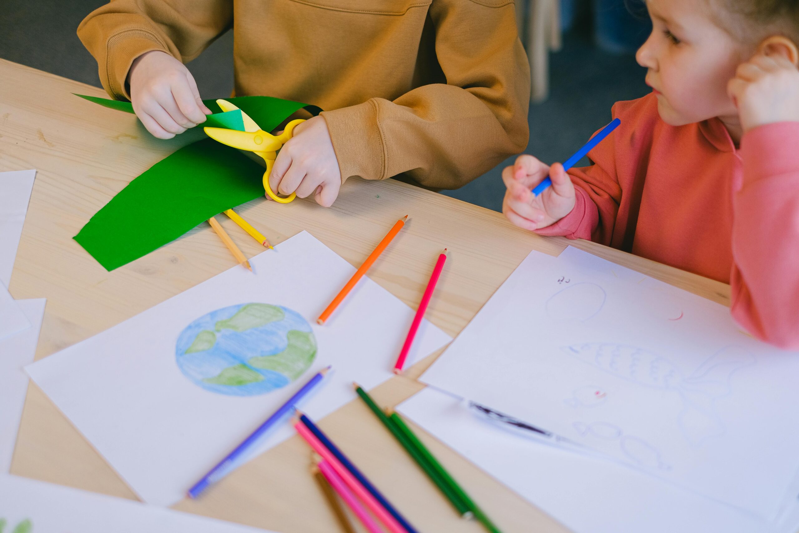 A child creating a colorful DIY craft project using paper, glue, and markers